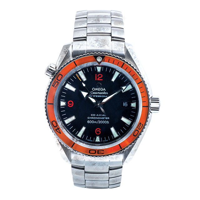 Before restoration of pre-owned Omega Seamaster in stainless steel with a black dial and orange bezel.