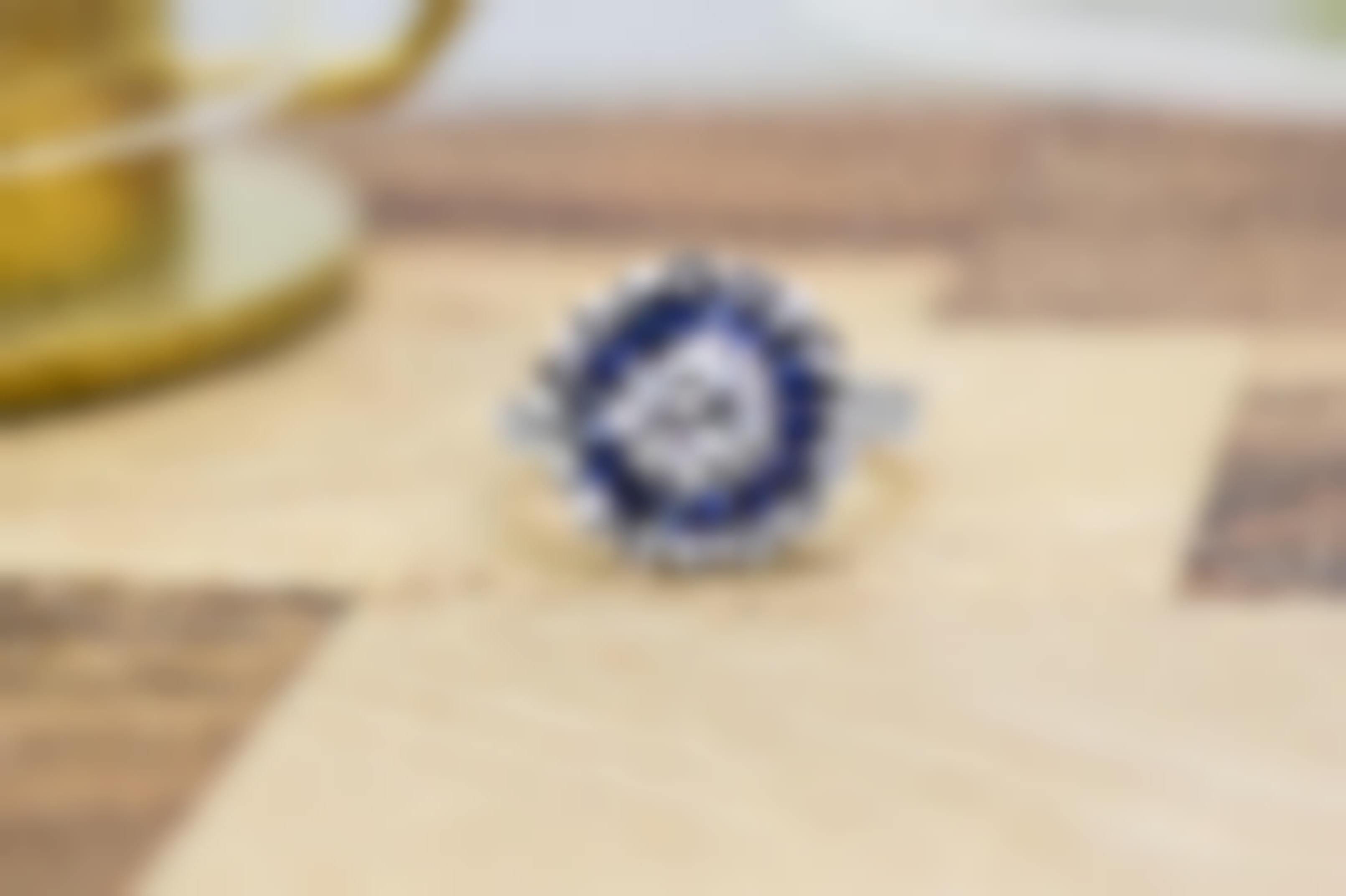 White gold diamond engagement ring with diamond and blue sapphire haloes.