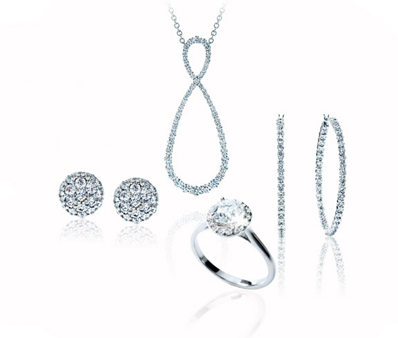 White gold necklace, ring, and two pairs of earrings all set with diamonds.