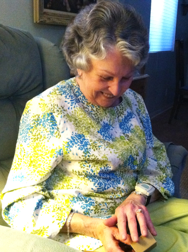 Older woman wearing yellow gold diamond engagement ring.