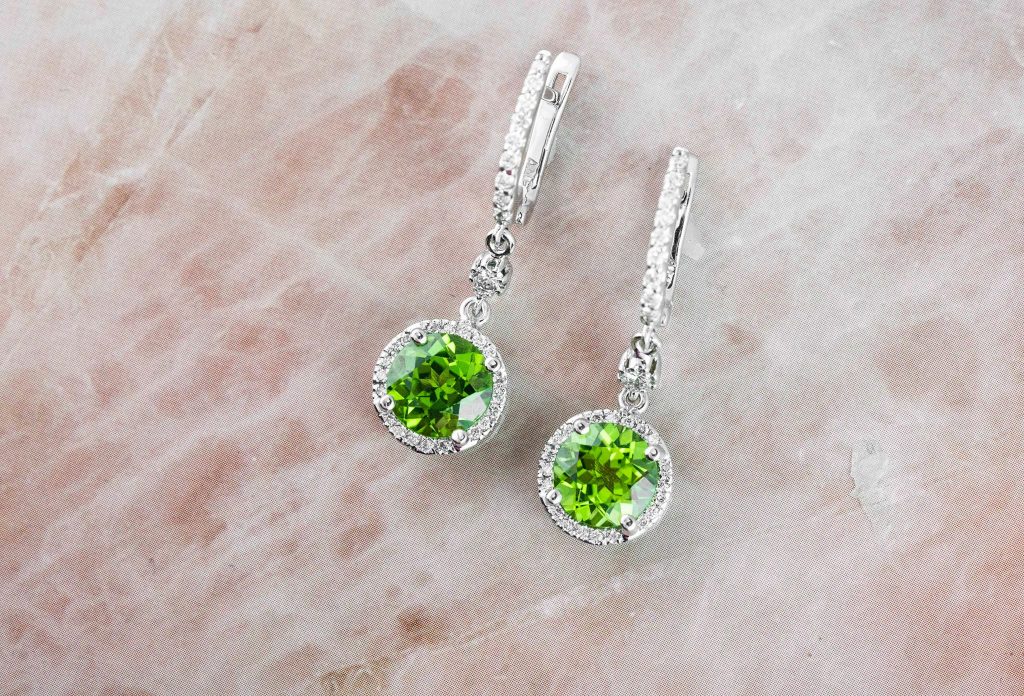 White gold drop earrings set with peridot and diamond haloes.