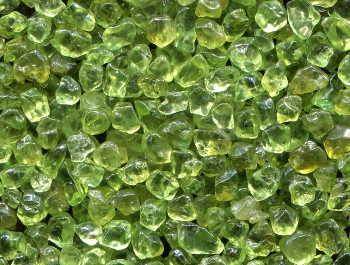 Pile of rough uncut peridot stones.