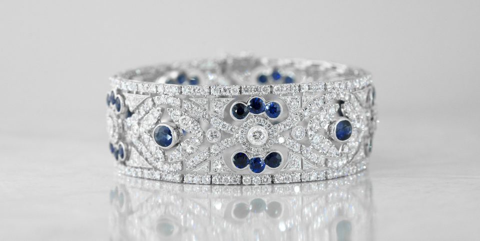 White gold wide cuff bangle set with diamonds and blue sapphires.