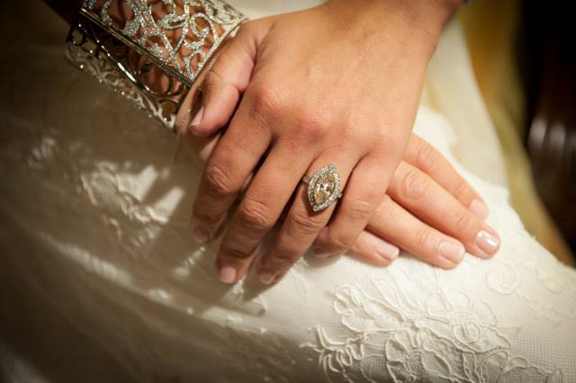 Bride’s hand featuring diamond engagement ring.