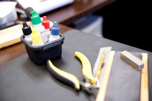 Set of tweezers next to containers of nitric acid.