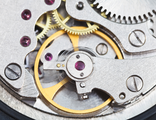 Close-up of inner movements and gears of a Rolex watch.
