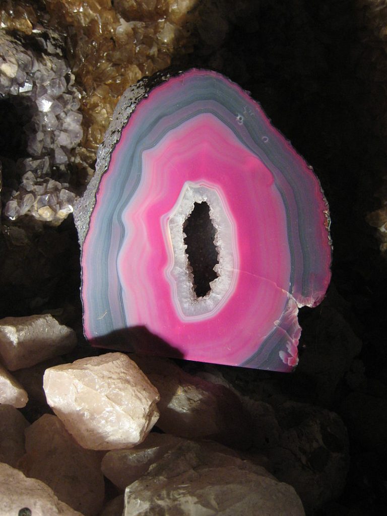 Center of mineral rock containing pink and gray crystallite formation.