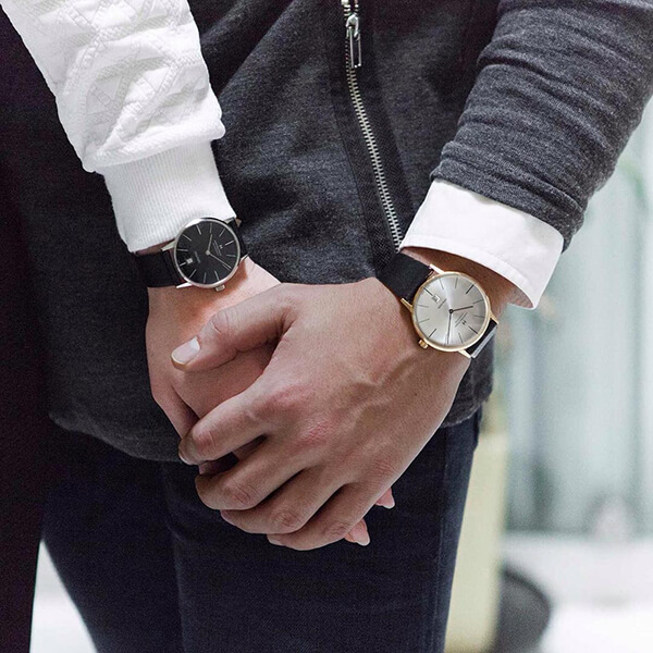 Couple holding hands both featuring Hamilton watches.