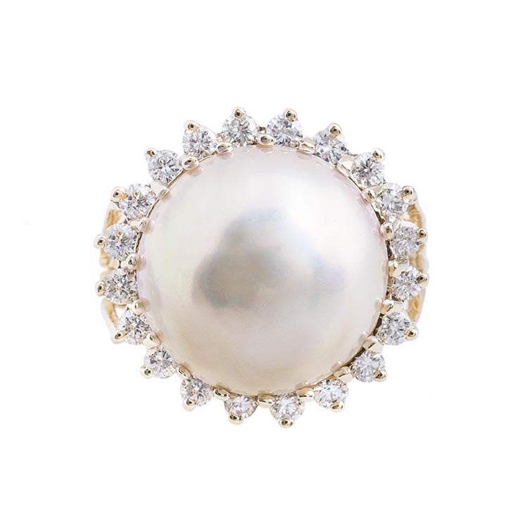 Yellow gold ring centered with a white pearl and diamond halo.