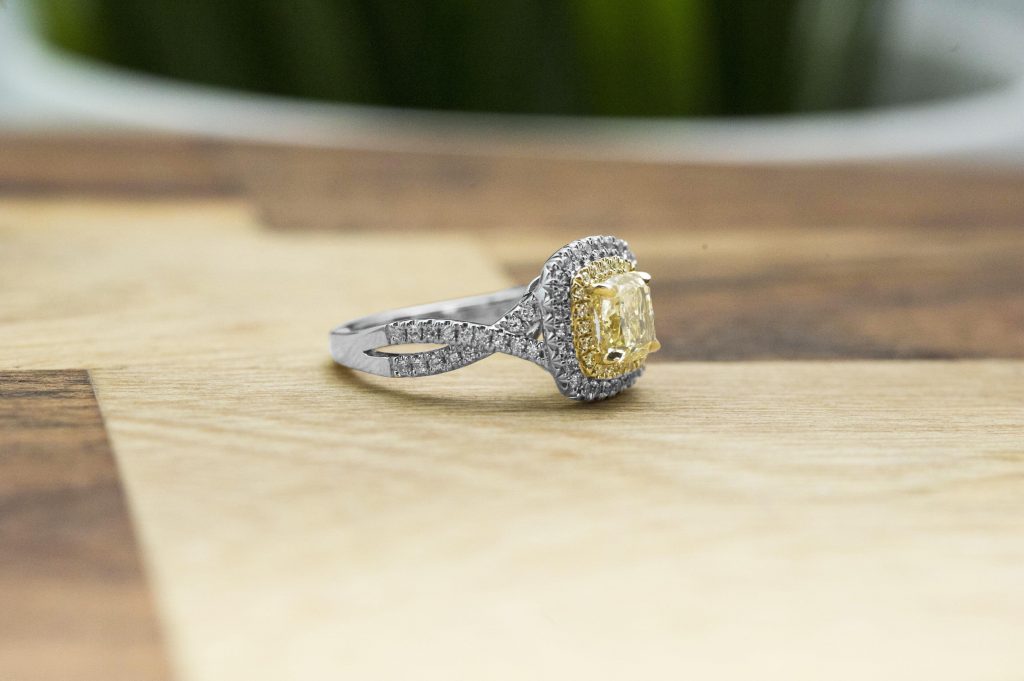 side view of Antique platinum twist engagement ring centered with a fancy light yellow diamond and
a white diamond halo.