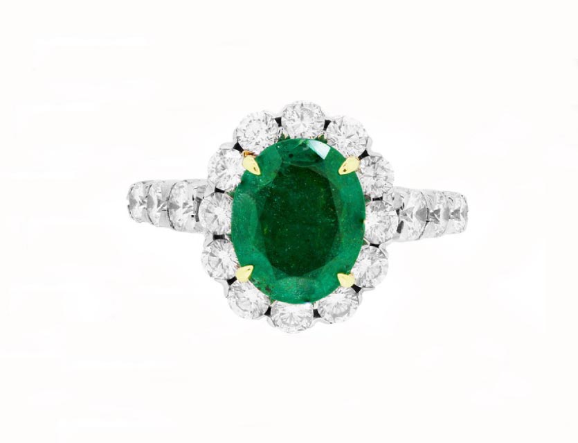 White gold engagement ring centered with an emerald surrounded by a diamond halo and
diamonds in the band.