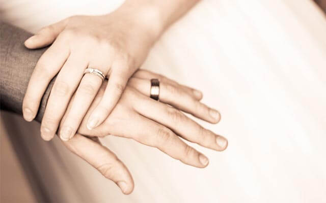 Bride and groom’s hands featuring their wedding bands.