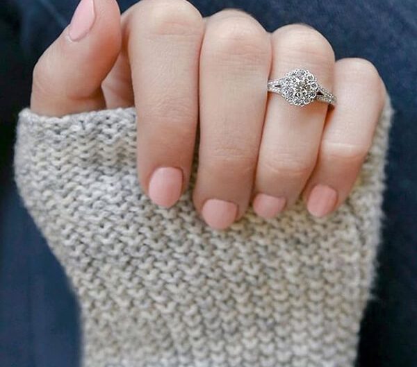 Woman’s hand featuring white gold diamond engagement ring.