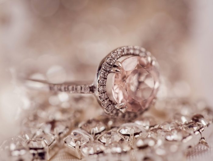 Rose gold morganite and diamond engagement ring set on various diamond jewelry.