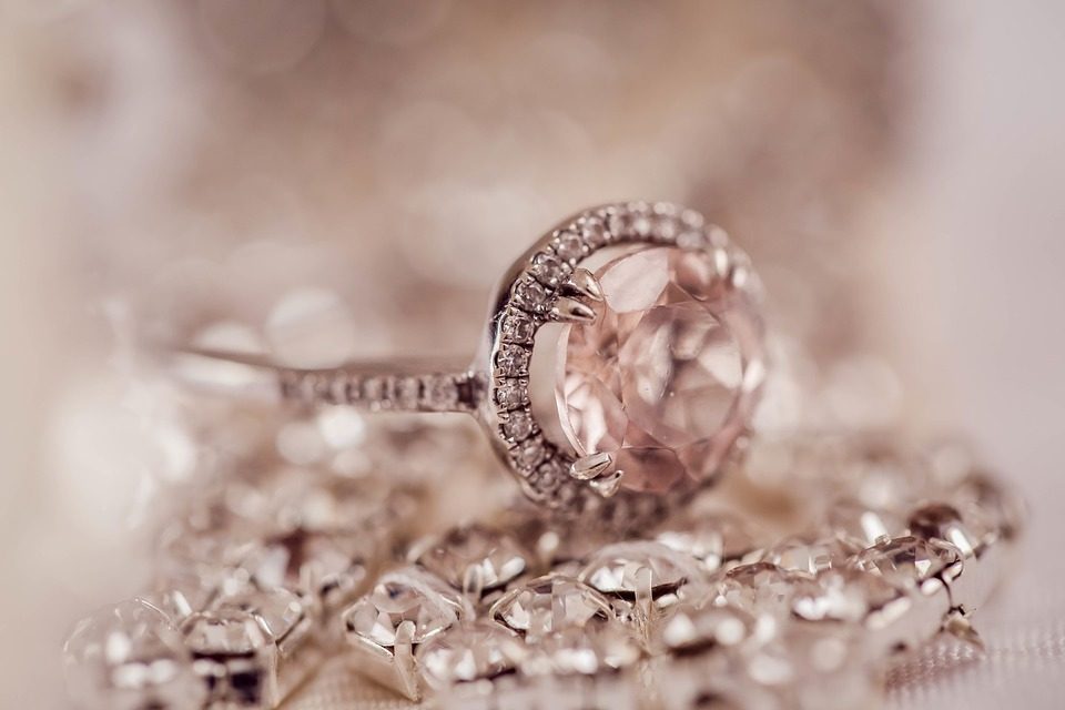 Rose gold morganite and diamond engagement ring set on various diamond jewelry.