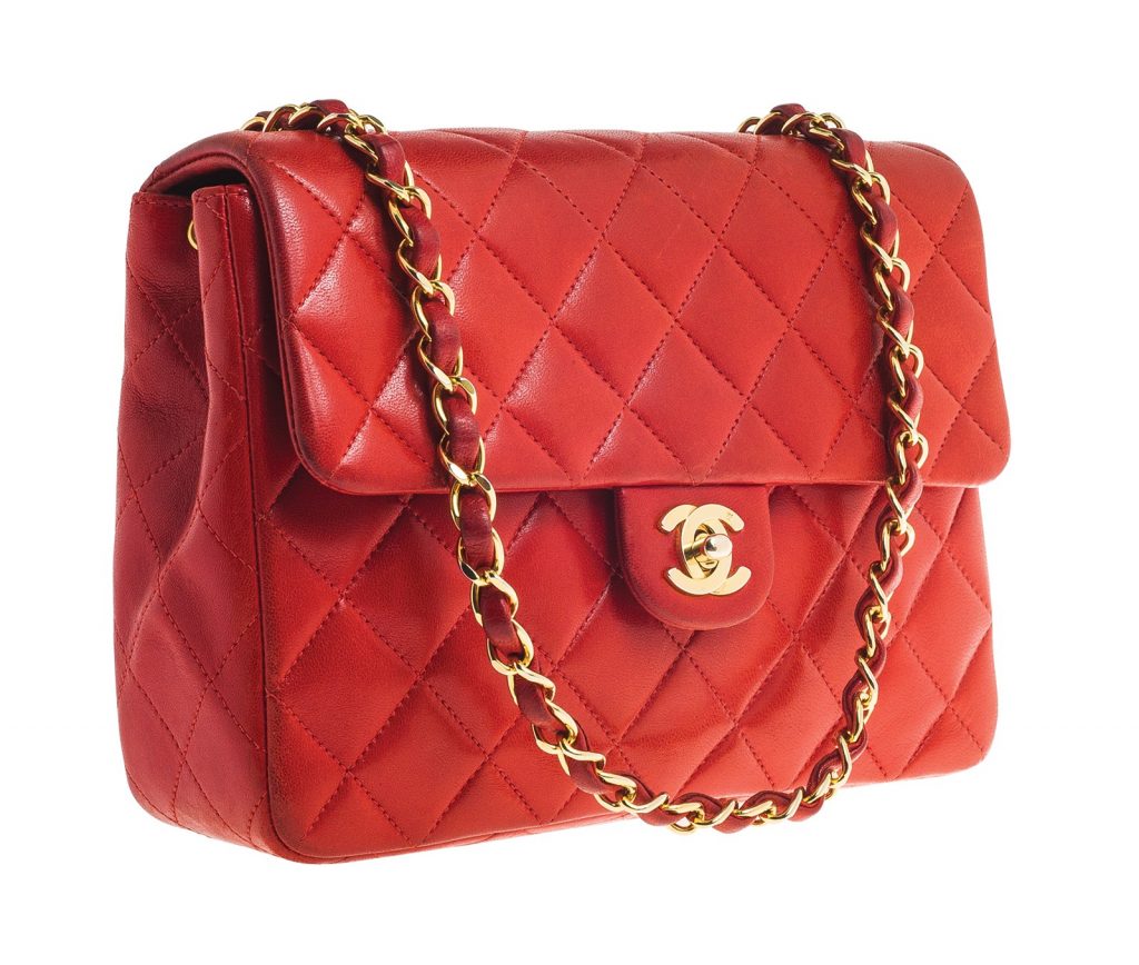 Vintage red lambskin Chanel Classic Flap handbag with a yellow gold and leather strap.