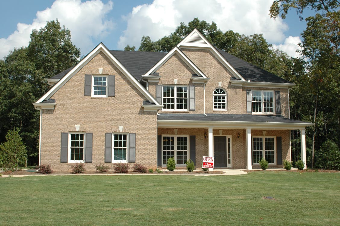 Two-story house with a porch and large front yard.