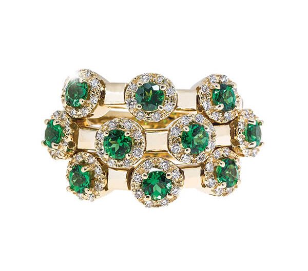 Yellow gold three-row flexible ring set with emeralds and diamonds.