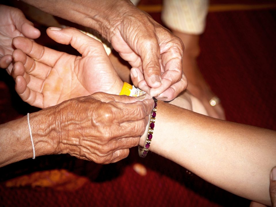 Man putting a bracelet onto a woman’s wrist.