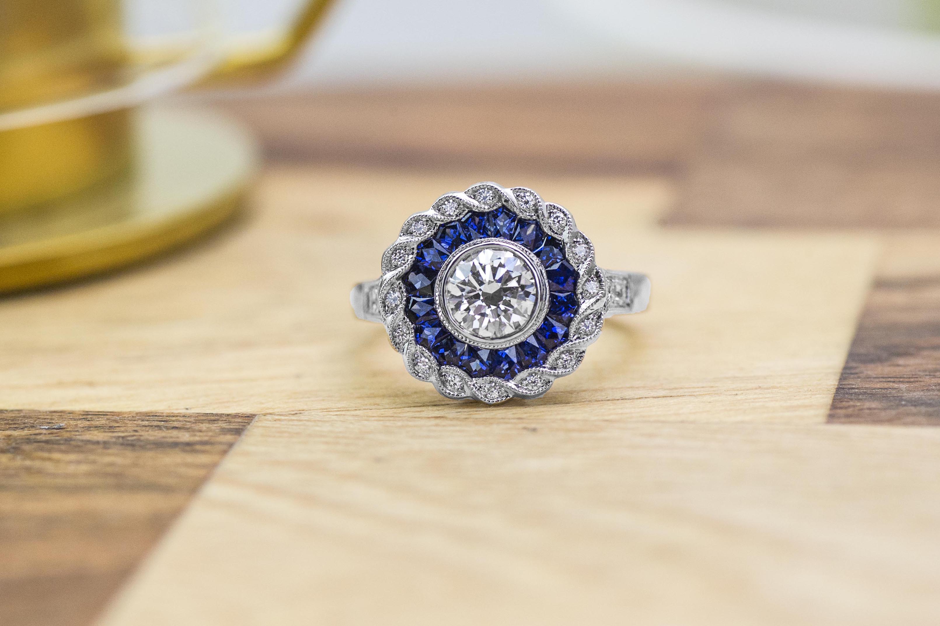 White gold diamond engagement ring with diamond and blue sapphire haloes.