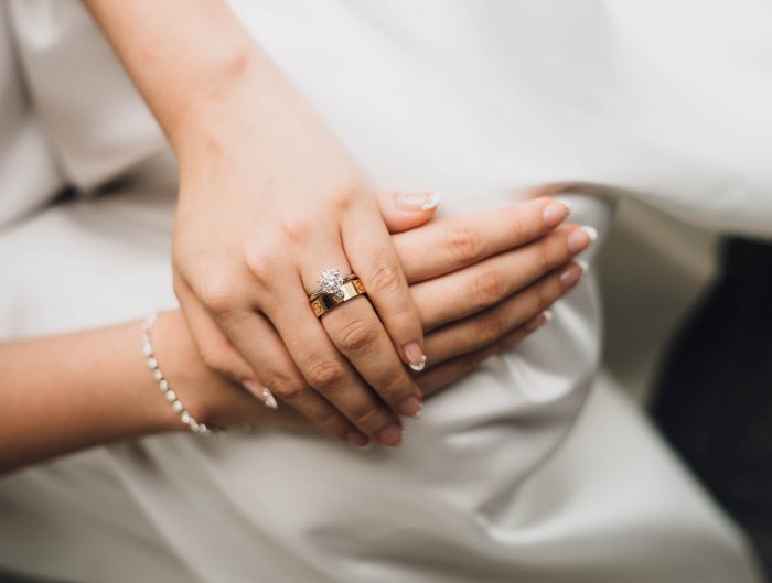 Woman’s hands featuring bracelet and wedding ring.