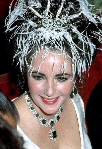 Elizabeth Taylor pictured wearing one of her emerald and diamond statement necklaces.