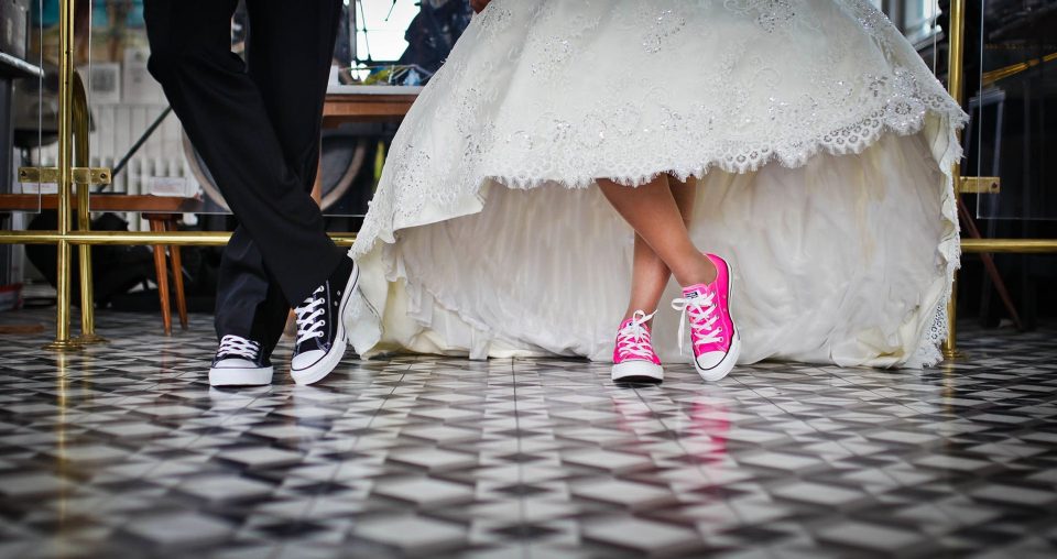 Bride and groom wearing pink and black converse for their ceremony.