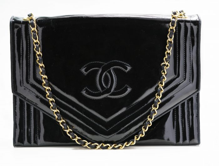 Vintage black Chanel handbag with gold and leather chain.