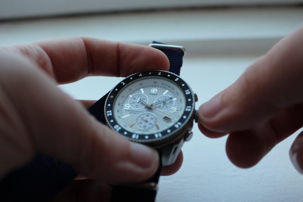 Person setting the time on a watch.