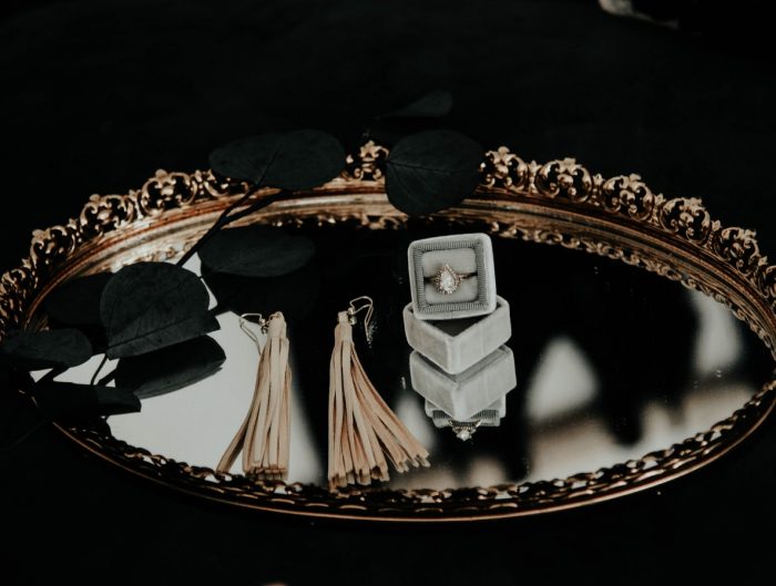 Various jewelry pieces displayed on a mirrored tray.