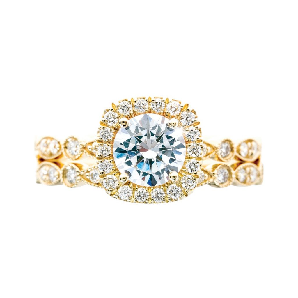 Yellow gold wedding set centered with a diamond surrounded by a diamond halo with diamonds in the bands.