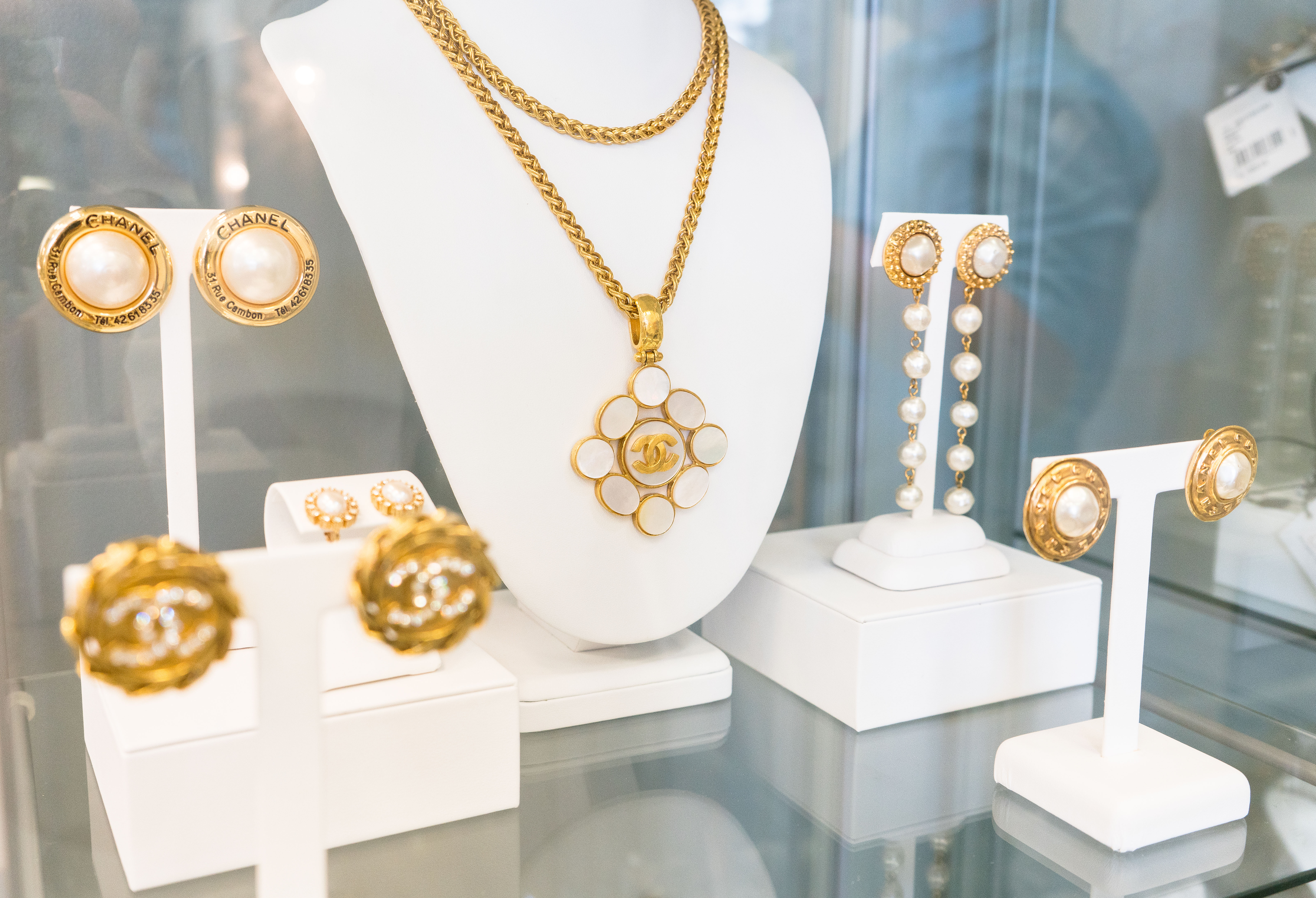 Yellow gold vintage Chanel earrings and necklace on display.