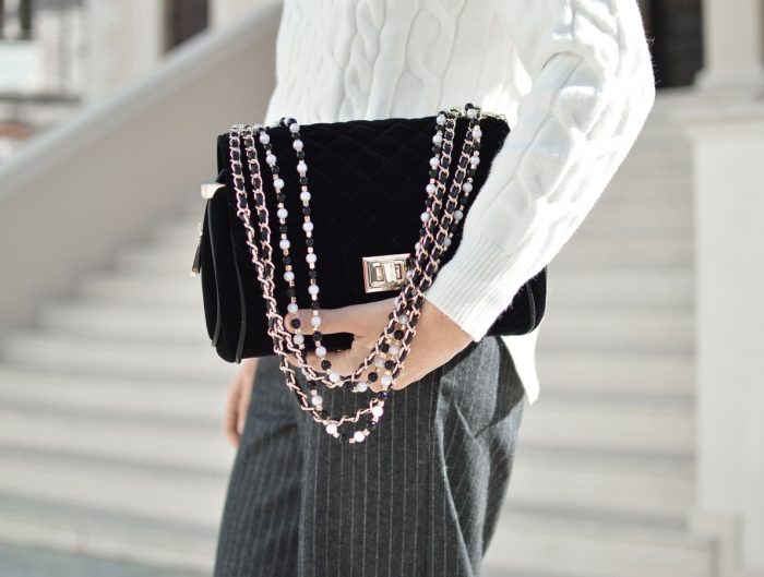 Large black handbag with beaded gold and leather chain strap.