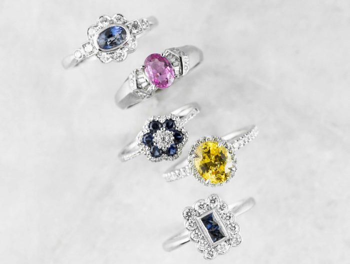 Five white gold engagement rings centered with different colored gemstones.