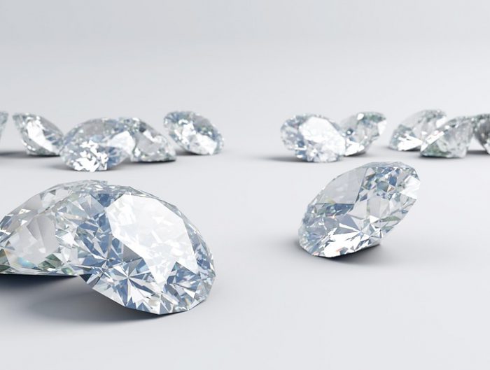 Several loose round cut diamonds on white background.