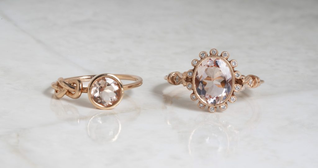 Two yellow gold engagement rings set with morganite and diamonds.