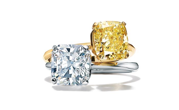 Two vintage Tiffany & Co. engagement ring in white gold centered with a white diamond and in yellow gold centered with a fancy vivid yellow diamond.