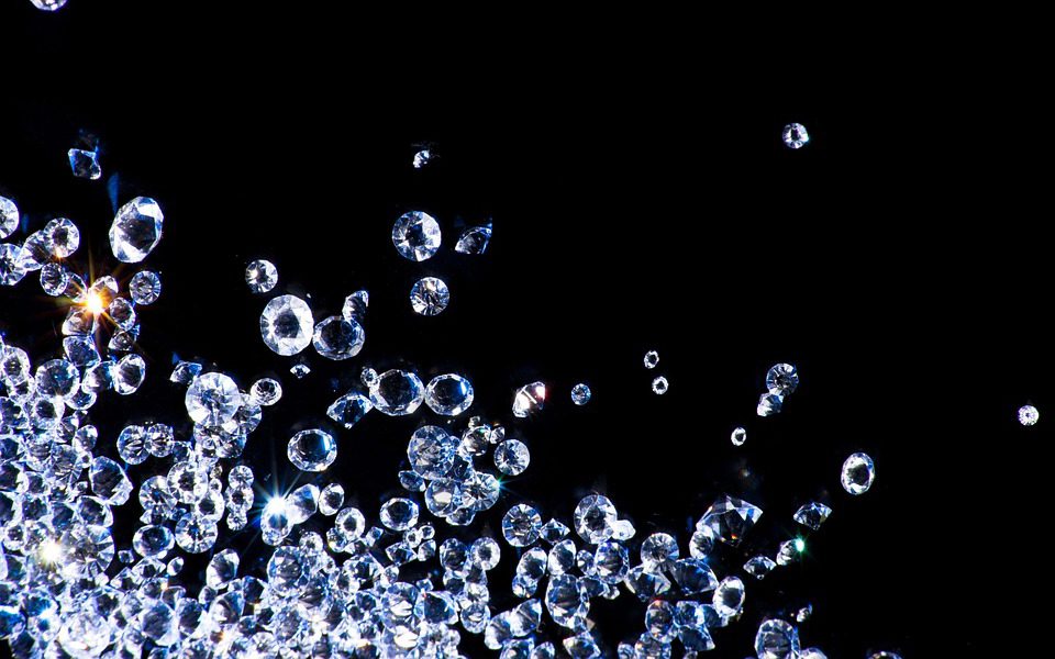 Loose cut diamonds on a black background.