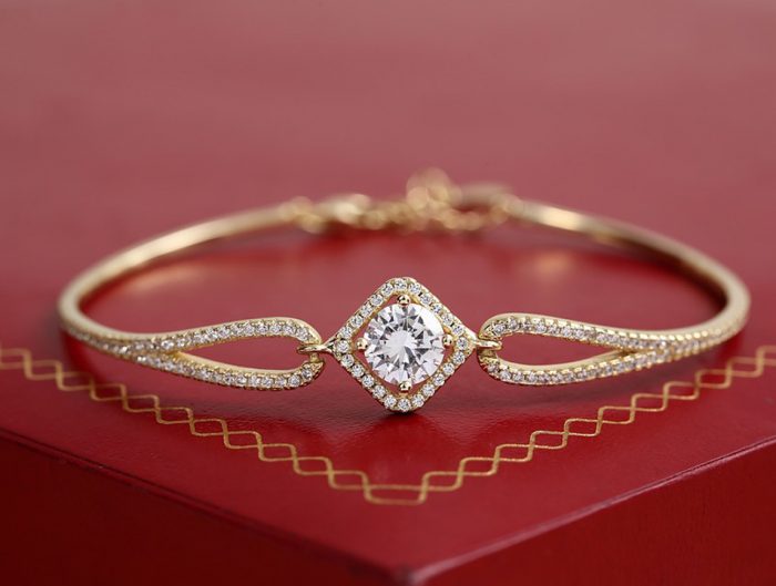 Yellow gold diamond bangle on a red box.