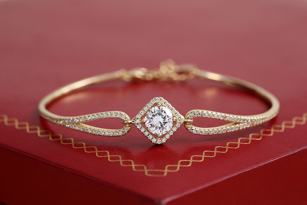 Yellow gold diamond bangle on a red box.