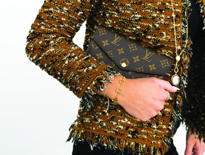 Woman clutching a vintage Louis Vuitton Monogram button wallet.