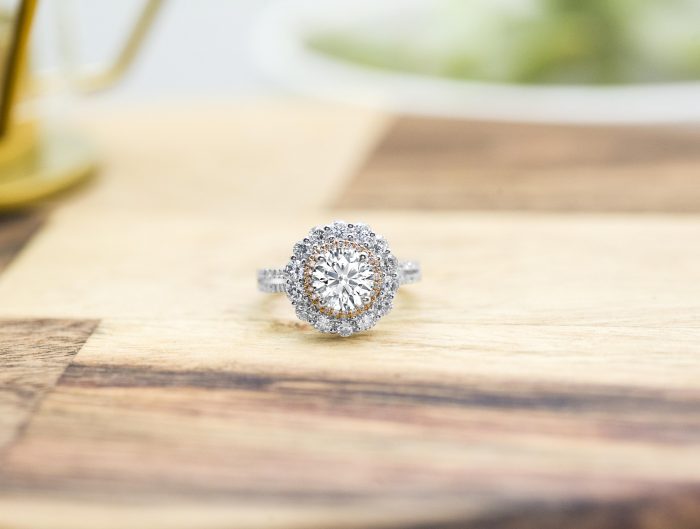 White gold diamond engagement ring surrounded by a diamond halo and diamonds in the band.