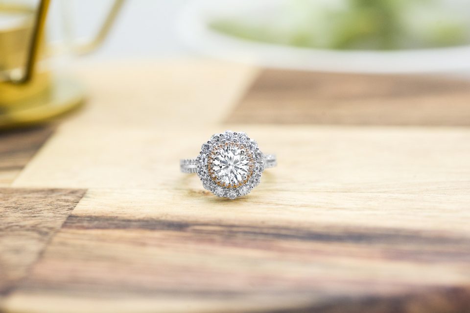 White gold diamond engagement ring surrounded by a diamond halo and diamonds in the band.