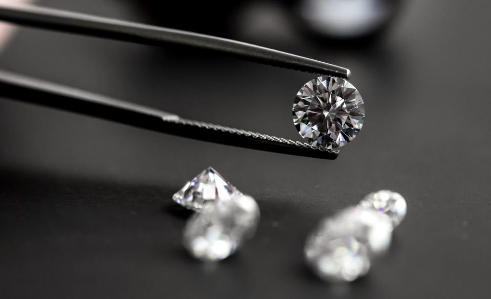 Tweezers holding a loose round cut diamond.