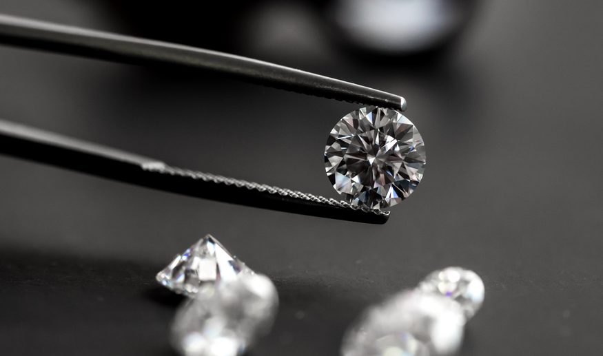 Tweezers holding a loose round cut diamond.