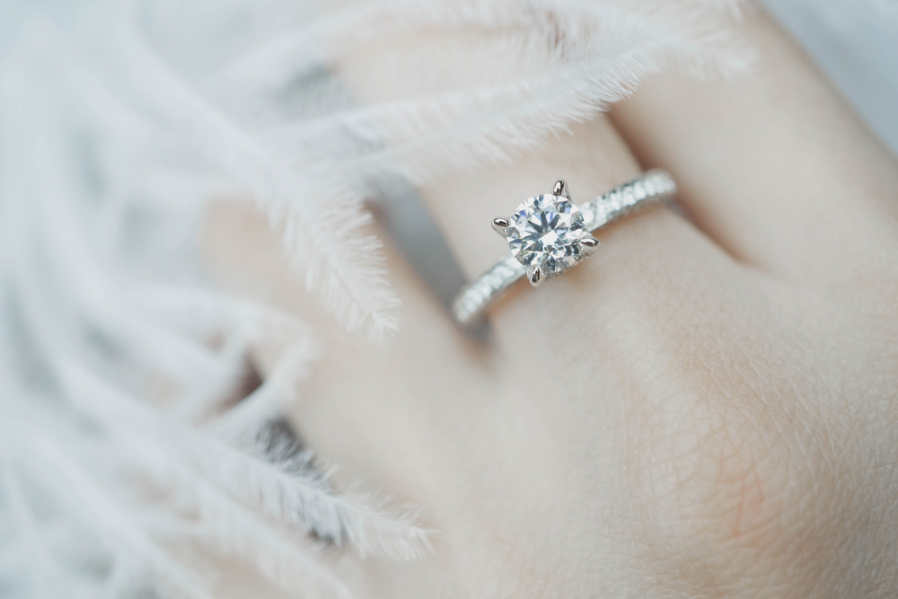 Woman’s hand featuring diamond engagement ring.