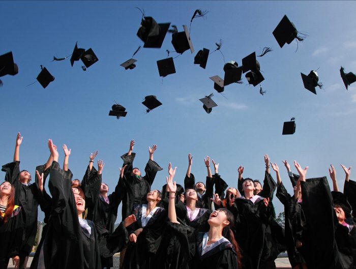 Graduates throwing caps in the air at ceremony.