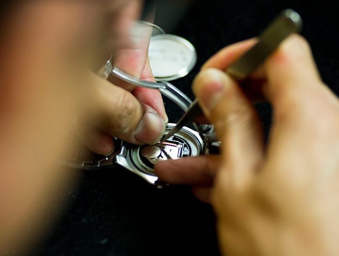 Jeweler working on watch repair at their bench.