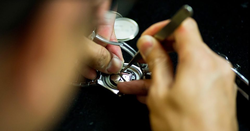 Jeweler working on watch repair at their bench.