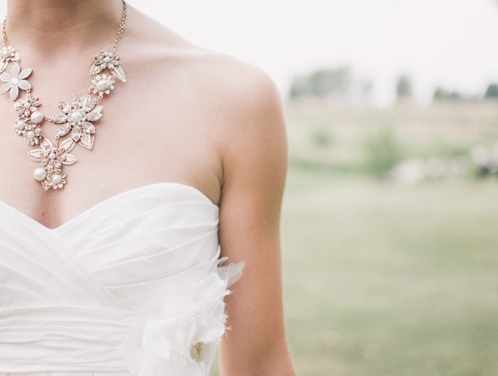 Bride wearing wedding gown and statement diamond necklace.